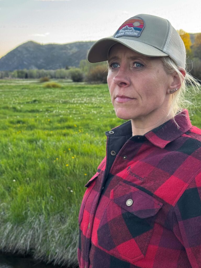 Portræt af Dea Larsen i et åbent landskab. Kendt fra Alene i Vildmarken sæson 10, lystfisker og indehaver af Outdoor i Centrum med en livslang passion for natur og friluftsliv.